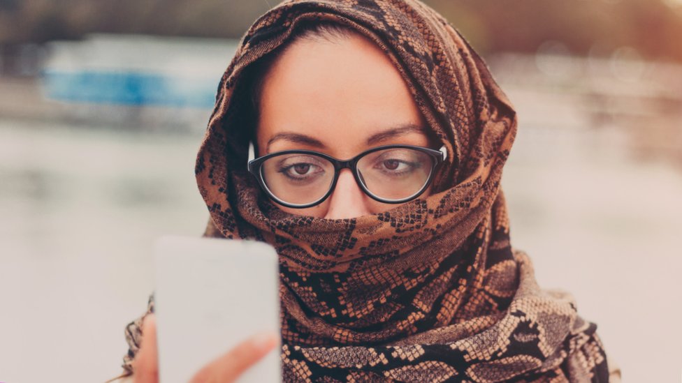 امرأة تنظر إلى هاتف
