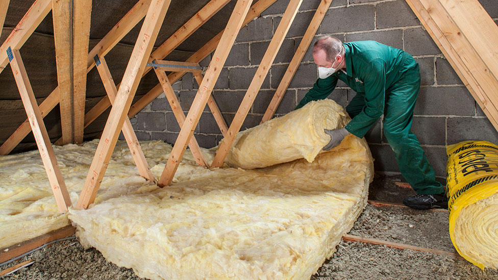 Man laying insulation in loft