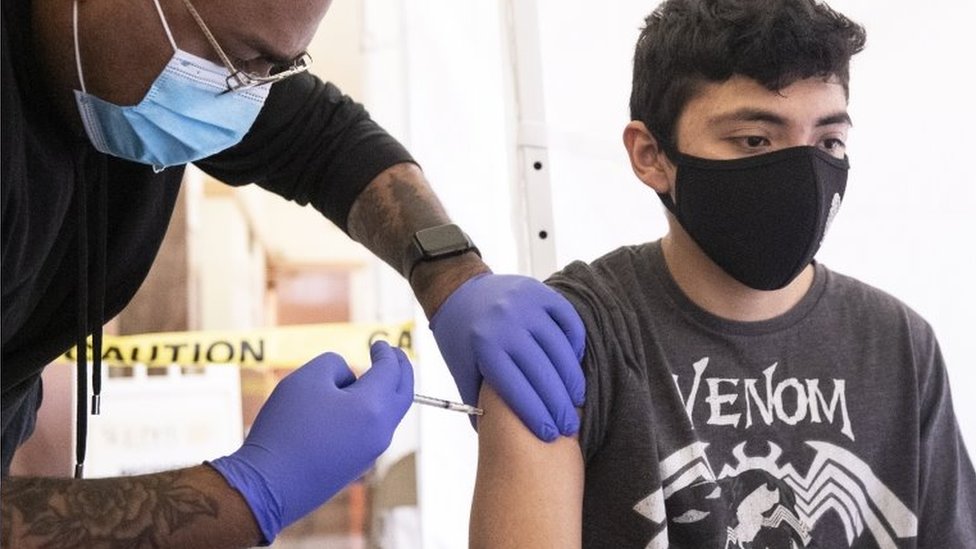 Homem jovem sendo vacinado