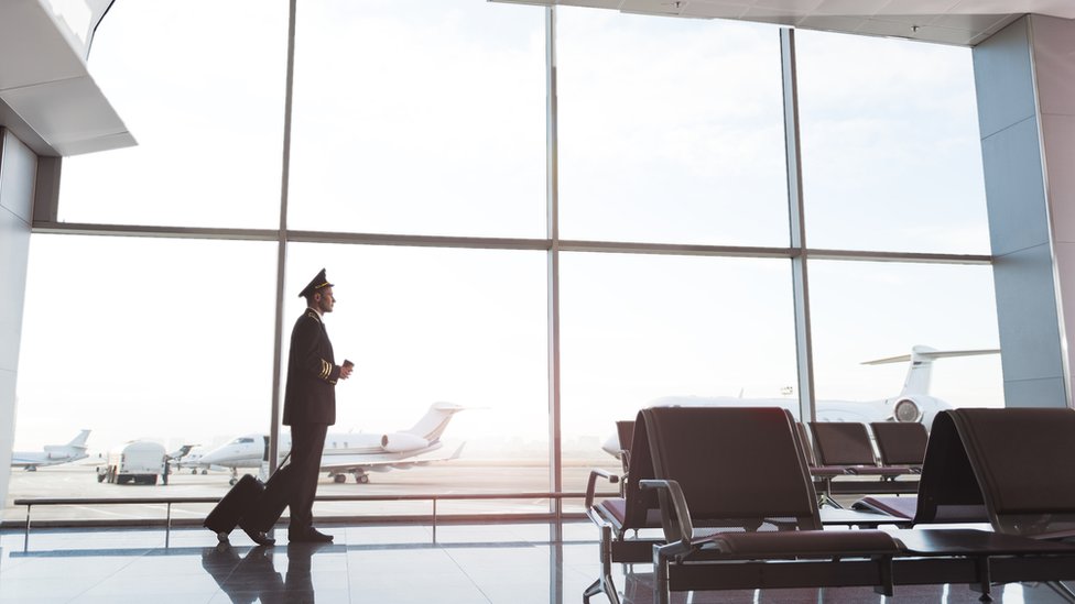 Piloto comercial caminando en un aeropuerto