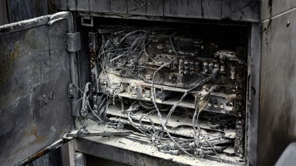 Поврежденные кабели и телекоммуникационное оборудование изображены после пожара на телефонной мачте, прикрепленной к дымоходу в переоборудованном жилом комплексе Fearnleys Mill в Хаддерсфилде, северная Англия, 17 апреля 2020 г. -