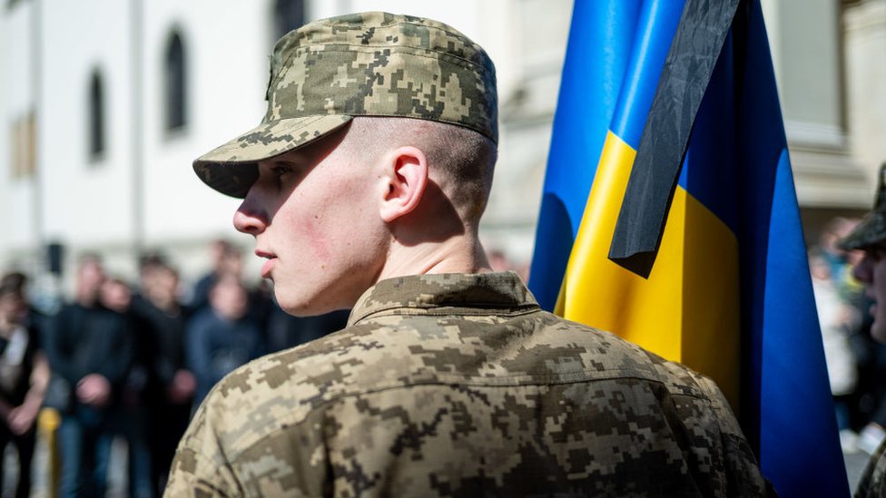 A soldier with the flag of Ukraine