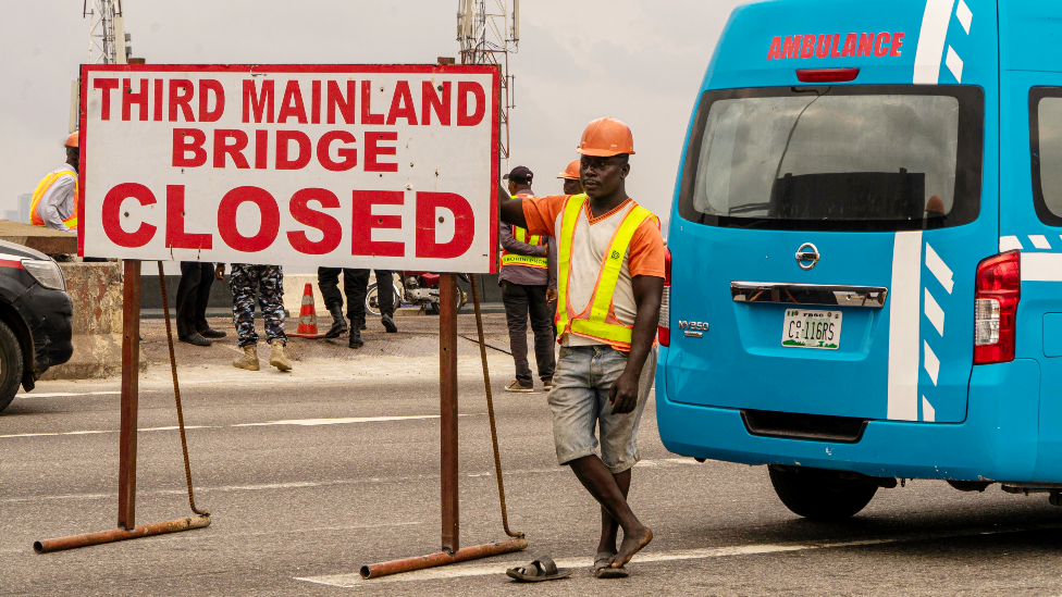 Рабочий и скорая помощь на Третьем материковом мосту, Лагос, Нигерия