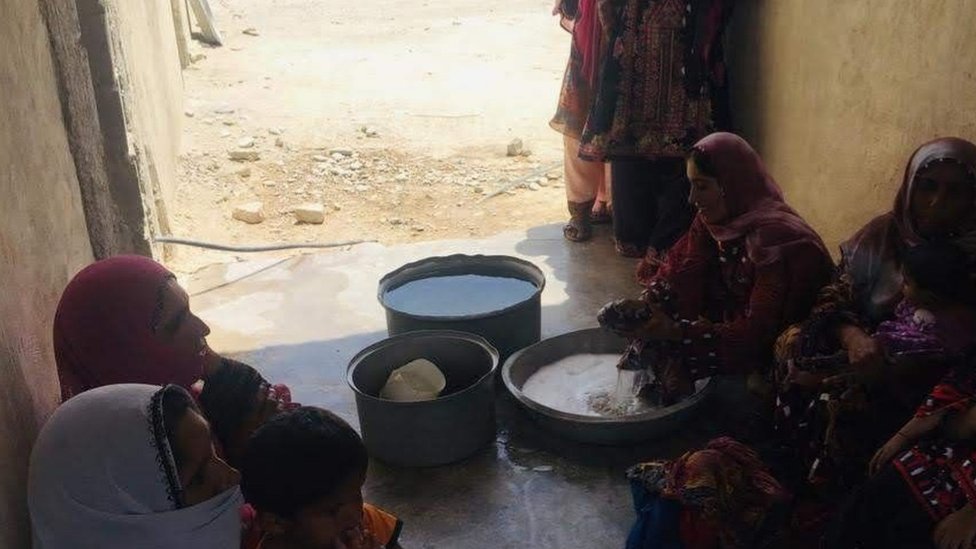 mulheres lavam roupas com balde d'água no Irã