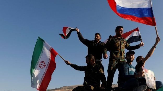 سوريون يرفعون الأعلام السورية والإيرانية والروسية