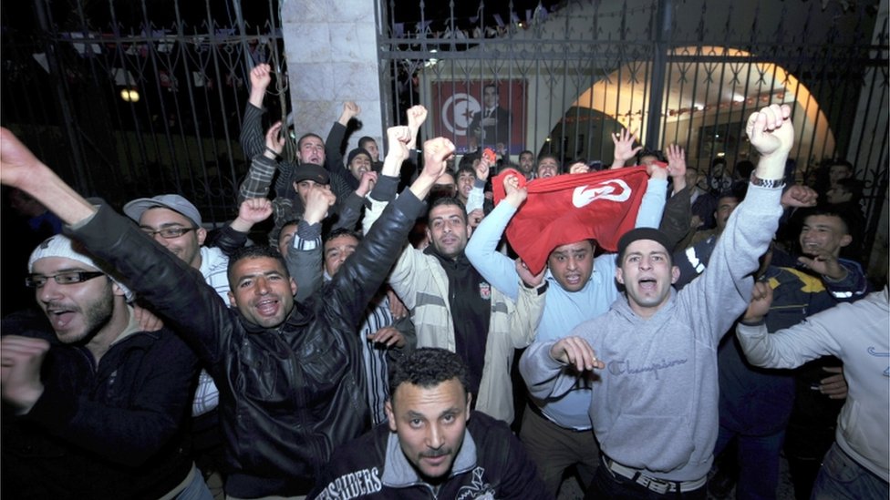 Люди в Тунисе празднуют объявление о том, что президент Зин эль-Абидин Бен Али уходит в отставку