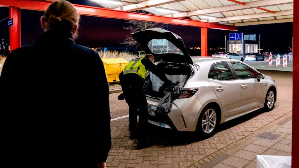 Un agente fronterizo en Hoek van Holland inspecciona el baúl de un auto que viene de Reino Unido