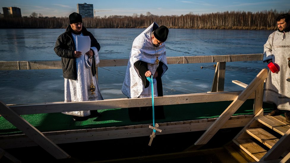 An Orthodox priest blesses water in Svyatoye, in the outskirts of the Russian capital Moscow