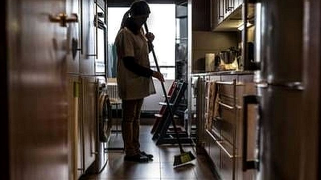 Mujer limpia la cocina de una casa.