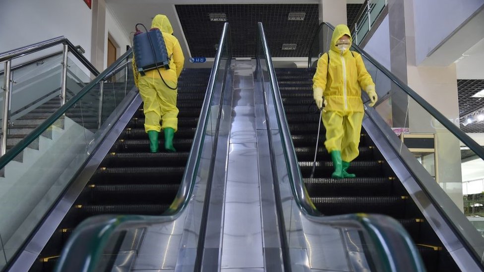 Los empleados rocían desinfectante como parte de las medidas preventivas contra el covid-19 en Pyongyang.