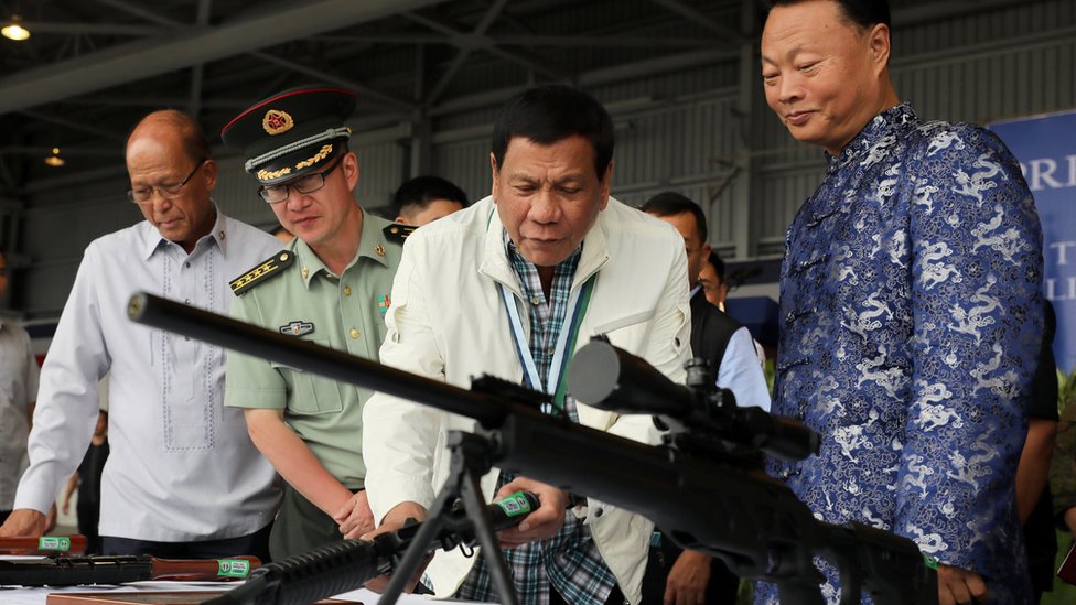 Philippine President Rodrigo Duterte (C) checking the scope of a Chinese-made CS/LR4A sniper rifle during the ceremonial handover of military weapons from China to the Philippines at the Clark Air Base in Pampanga province, Philippines, 28 June 2017