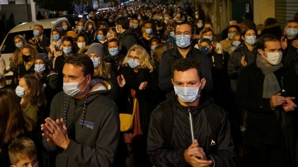 People attend a silent march to pay tribute to Samuel Paty, the French teacher who was beheaded in Conflans-Sainte-Honorine. Photo: 20 October 2020