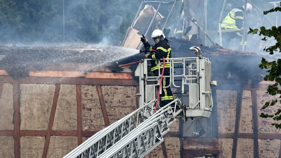 A firefighter sprays water on a building after a fire in a home for disabled people in Wintzenheim