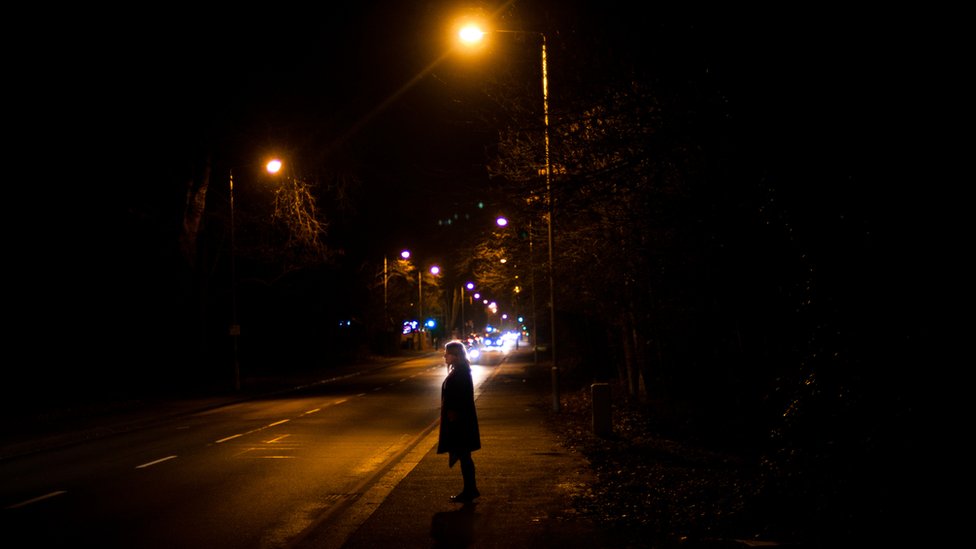 Gece sokak lambası altında bir kadın