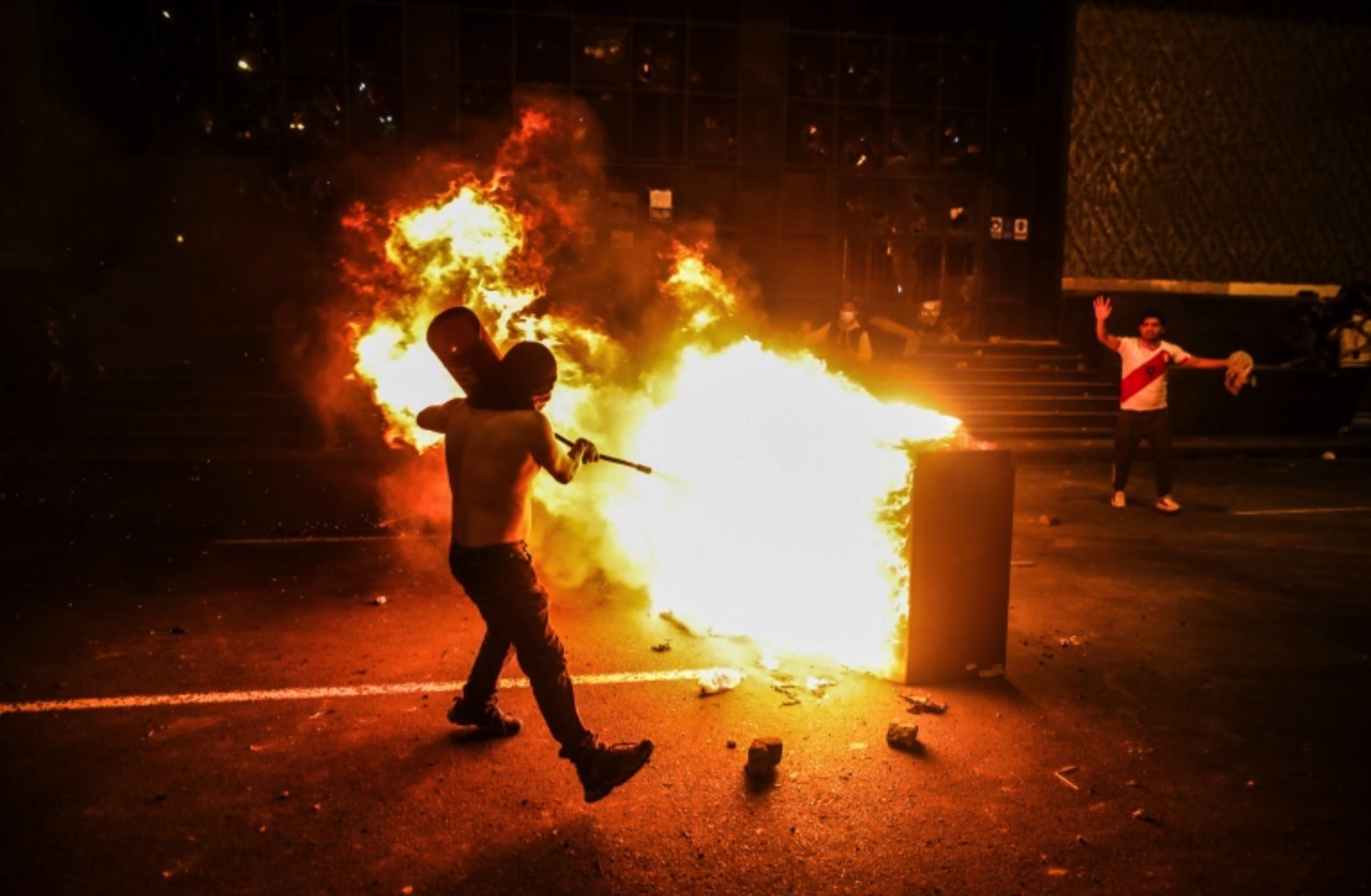 Manifestante tenta apagar um incêndio em Lima