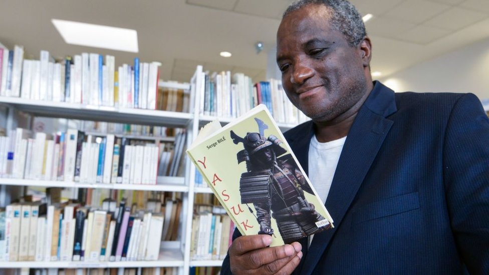 Penulis berdarah Prancis-Pantai Gading Serge Bilé memegang buku yang ditulisnya, "Yasuke"