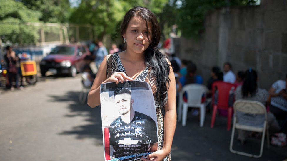 Элизабет дель Росарио Кано Молина держит фотографию своего мужа