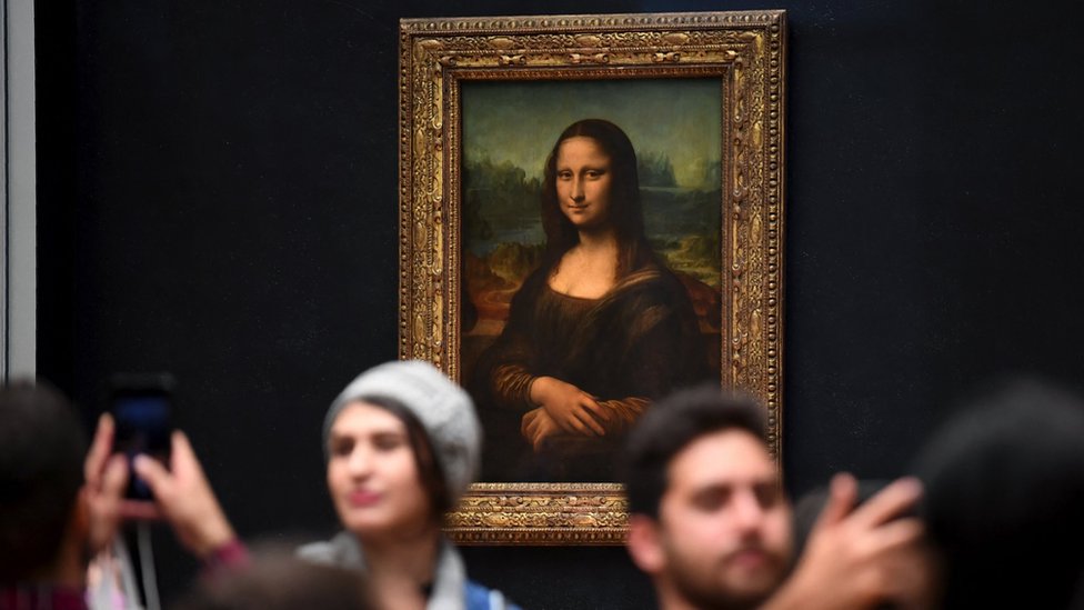Posetioci se slikaju ispred Mona Lize, kada je slika vraćena u muzej Luvr u Parizu 7. oktobra 2019.