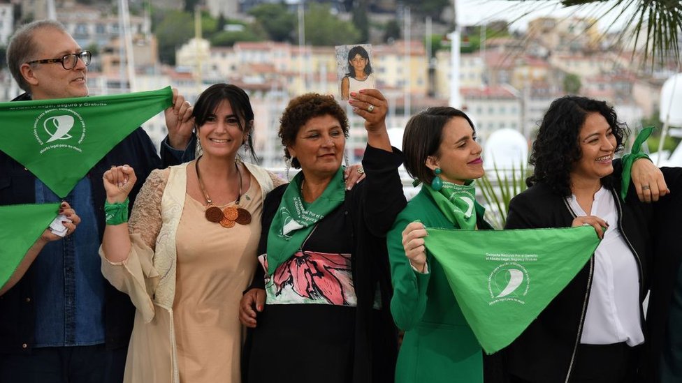 La activista pro-elección Norma Noemí Cuevas (centro) muestra una foto de su hija, Ana María Acevedo, que murió hace 12 años. A la izquierda, el cineasta argentino Juan Solanas en el Festival de Cannes. 18 de mayo de 2019.