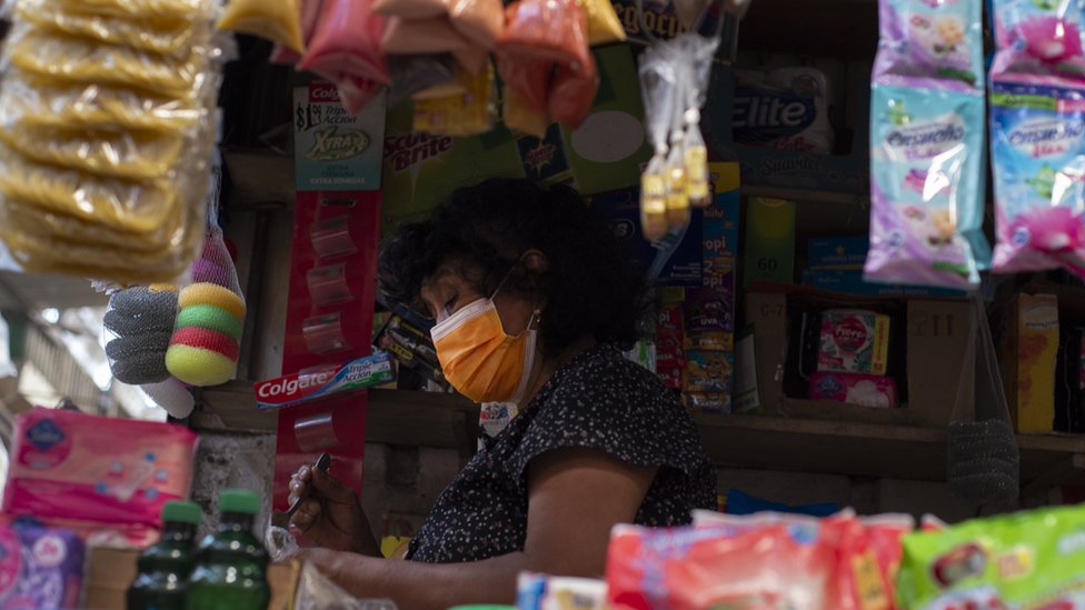 Una mujer atiende en un comercio en El Salvador.