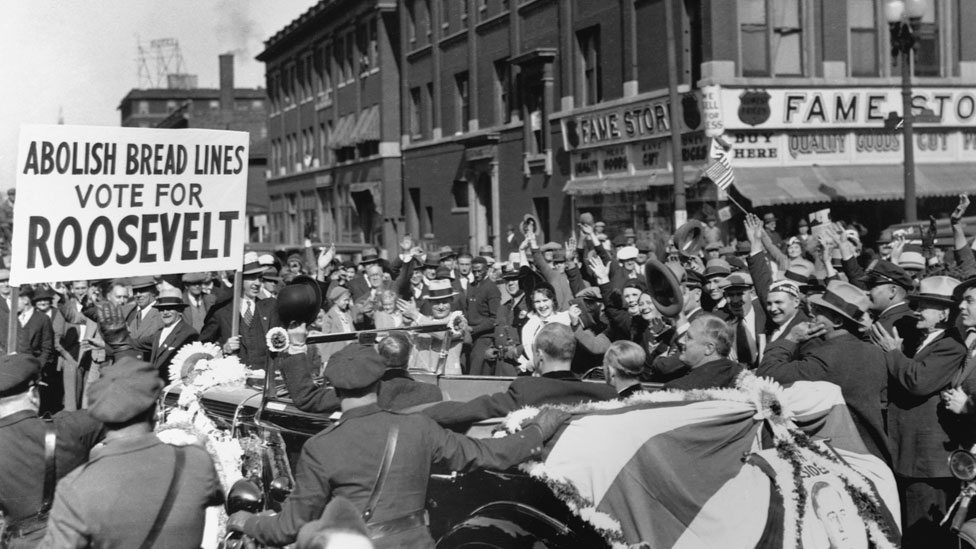 Un acto partidario de Roosevelt en Indianapolis, en 1932, con un cartel que dice: "Elimina la fila para recibir ayuda social, vota a Roosevelt".