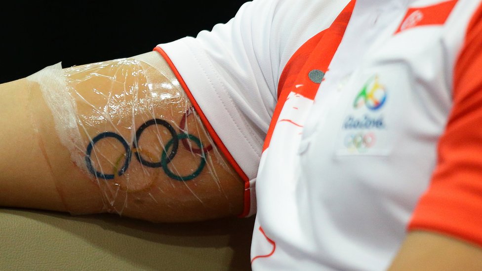 Татуировка Олимпийских колец видна на руке сингапурского пловца Джозефа Скулинга, когда он разговаривает со СМИ во время пресс-конференции в водном центре OCBC 16 августа 2016 года в Сингапуре
