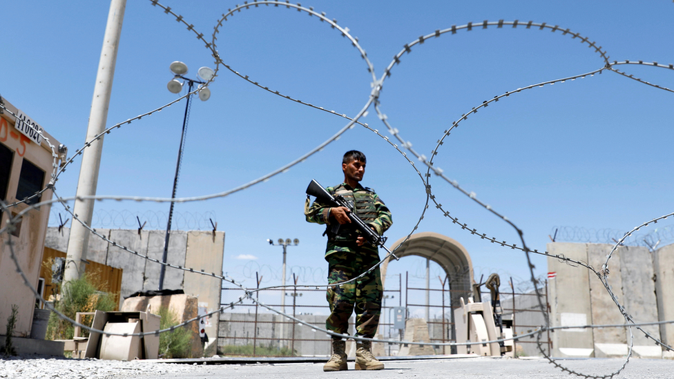 جندي من الجيش الوطني الأفغاني يقف في حراسة بوابة قاعدة باغرام الجوية الأمريكية.