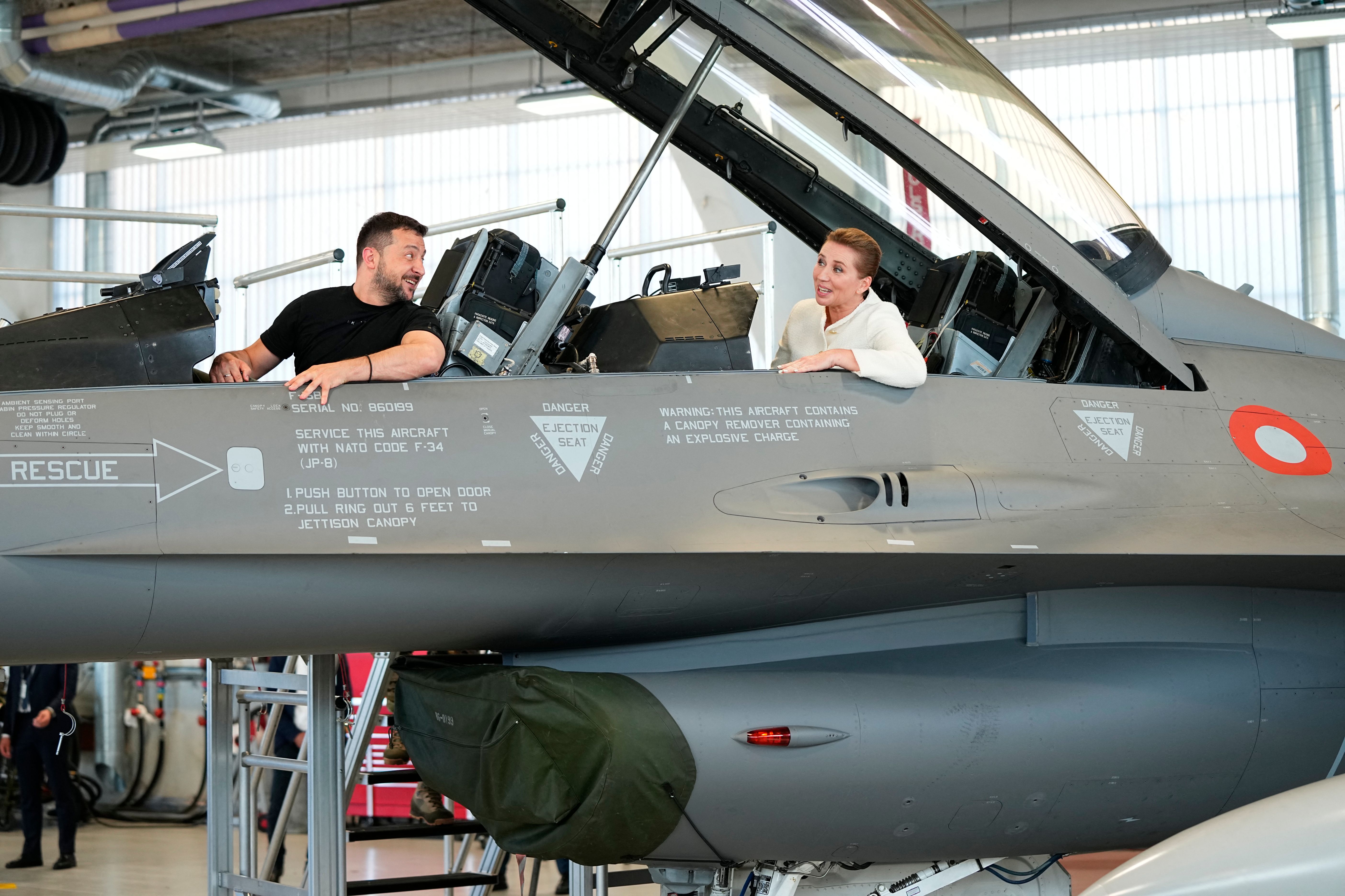 Ukrainian President Volodymyr Zelensky and Danish Prime Minister Mette Frederiksen sit in a F-16 fighter jet