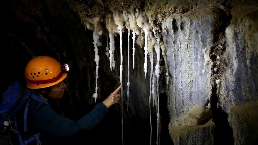Istraživačica gleda stalaktite u pećini Malham