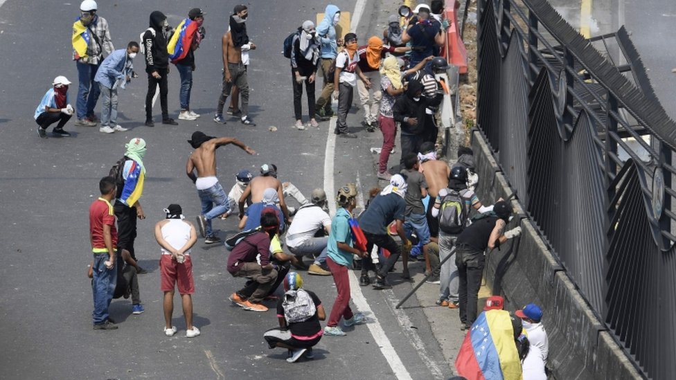 Manifestantes arrojan piedras en Venezuela.