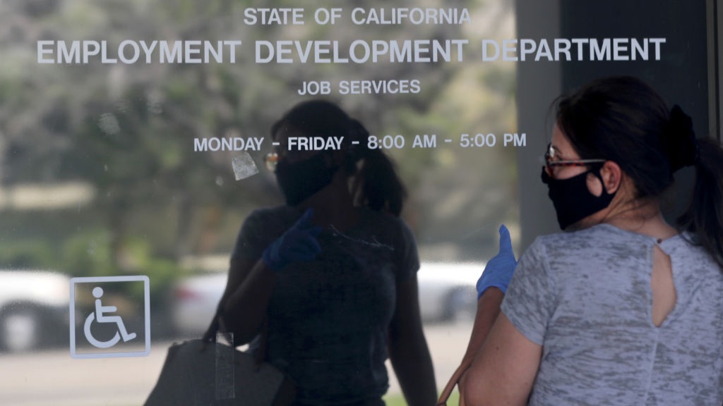 Женщина у здания закрытого офиса Департамента занятости штата Калифорния из-за коронавируса.