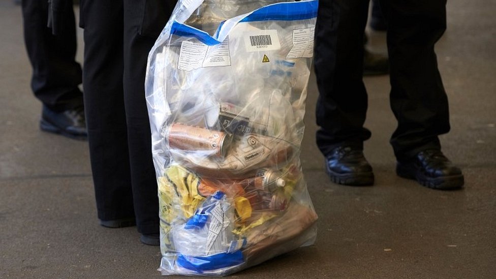 Офицеры британской транспортной полиции стоят с мешками для вещественных доказательств, когда они отправляются с вокзала Брикстон на юге Лондона