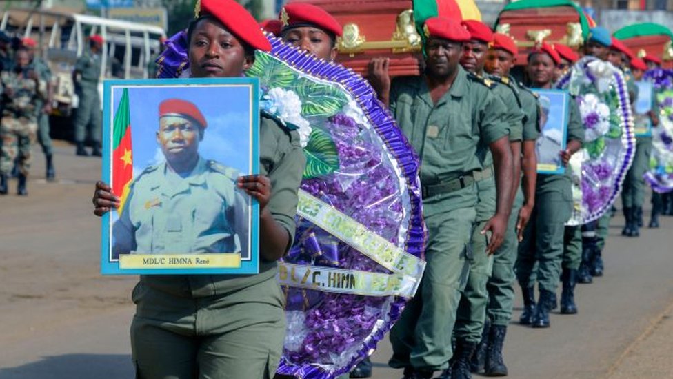 Soldados portando un ataúd y la foto de un compañero