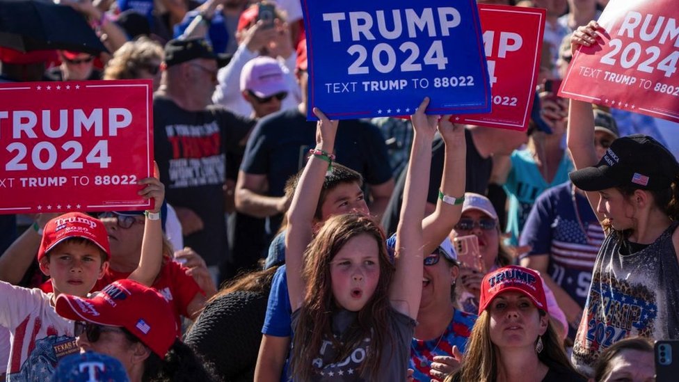 Young supporters of former US President Donald Trump hold a "Trump 2024" sign at a 2024 election campaign rally in Waco, Texas, 25 March 2023