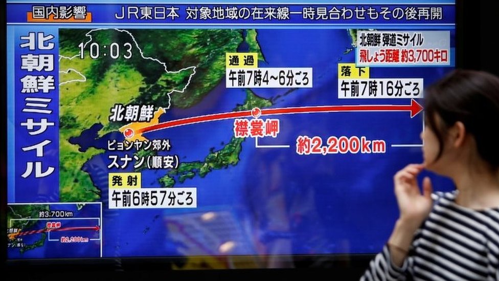 Прохожий смотрит на экран телевизора с новостями о пуске Северной Кореей ракеты в Токио (15 сентября 2017 г.)