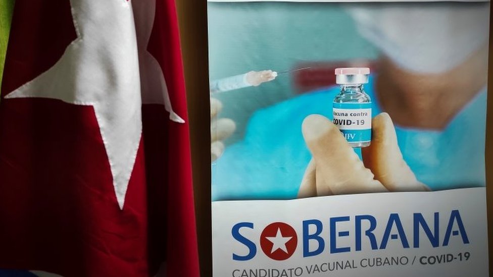 Um pôster de propaganda da vacina Cuba Soberana 2 Covid-19 está pendurado ao lado da bandeira nacional cubana no Instituto Finlay em Havana, Cuba, 20 de janeiro de 2021.