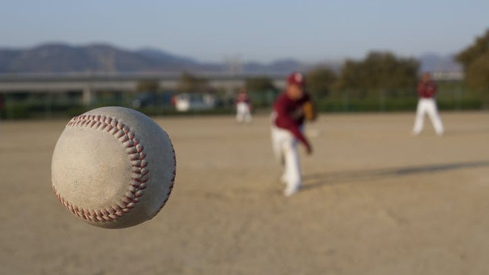 Un beisbolista lanzando una pelota