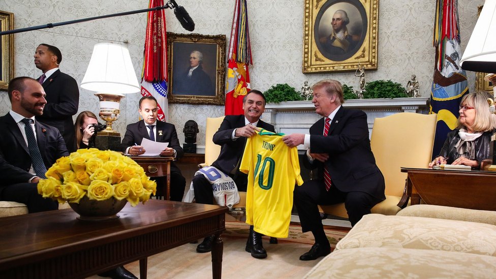 The Brazilian president, Jair Bolsonaro, gifts Trump a Brazil football jersey with his name on it during a meeting at the White House Oval Office on 19/03/2019
