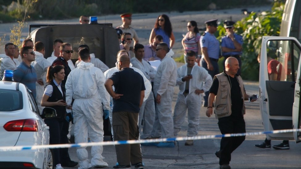 Полиция и судебно-медицинские эксперты стоят за блокпостом после того, как мощная бомба взорвала автомобиль, в результате которого погиб журналист-расследователь Дафна Каруана Галиция в Биднии, Мальта, 16 октября 2017 г.