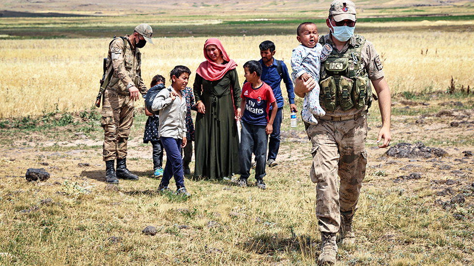 Turkish security forces patrolling the border with Iran help an exhausted Afghan family - 6 August 2021