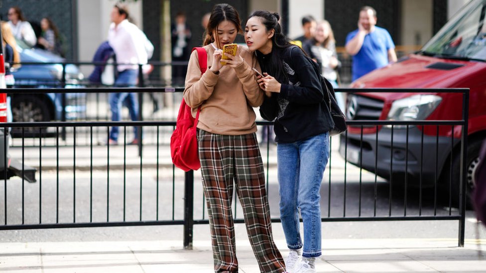 Mujeres viendo celular.