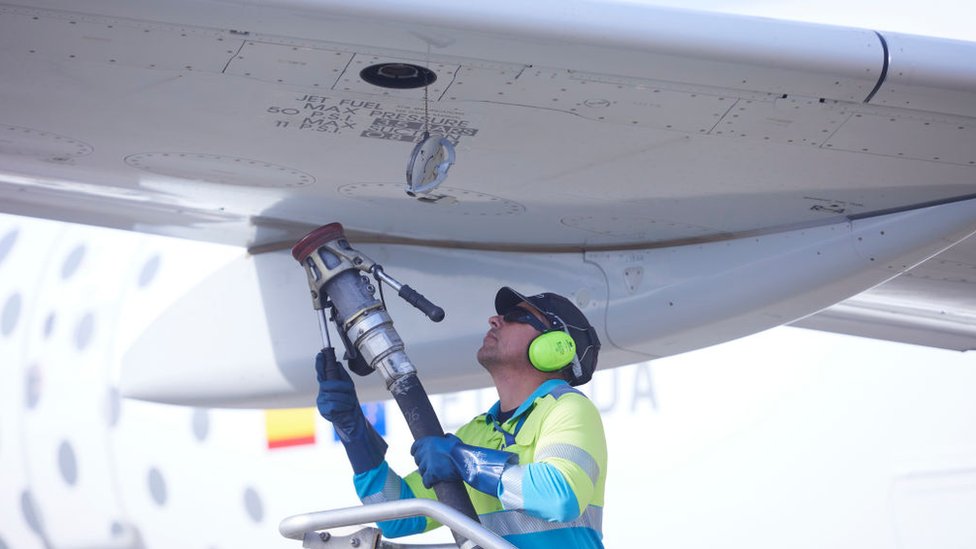 Un hombre cargando un avión de combustible.