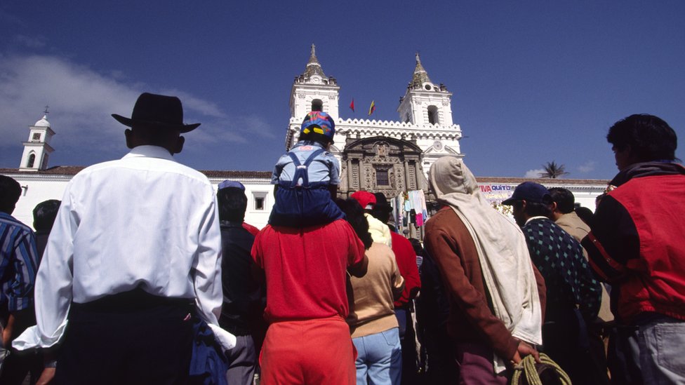 Personas de espaldas mirando a la iglesia de San Francisco, en Quito, Ecuador.