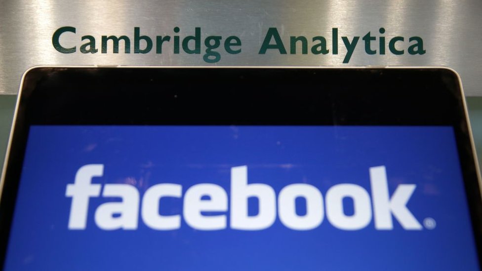 Portátil con el logo de Facebook y el directorio de Cambridge Analytica.