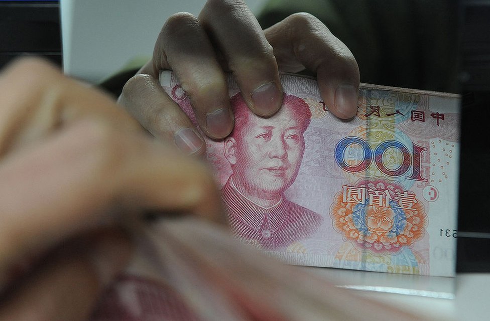 27 января китайский банковский служащий пересчитывает стопку банкнот 100 юаней в банке в Хэфэй, провинция Аньхой на востоке Китая. Февраль 2011