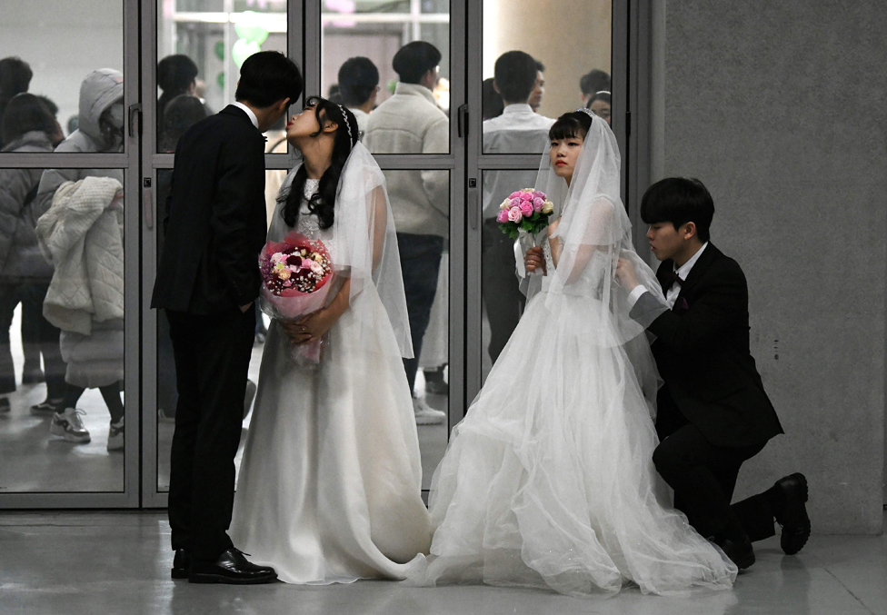 الأزواج وهم يستعدون لعروضهم في حفل زفاف جماعي تنظمه كنيسة التوحيد في غابيونغ