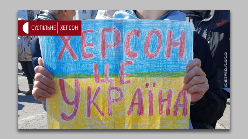 Image of child holding a poster that says "Kherson is Ukraine"