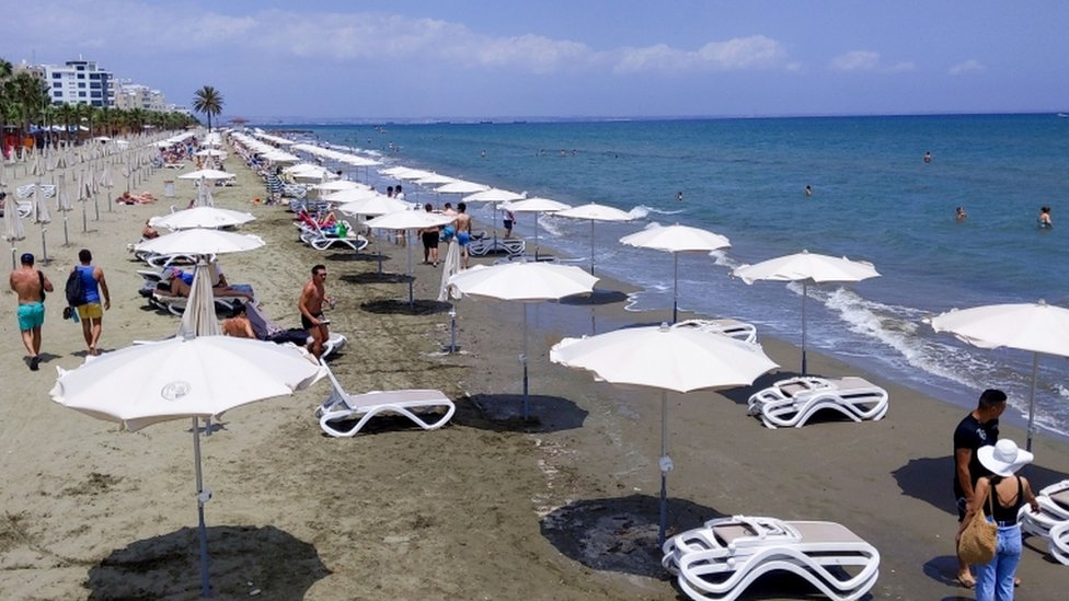 Люди гуляют по пляжу на Кипре