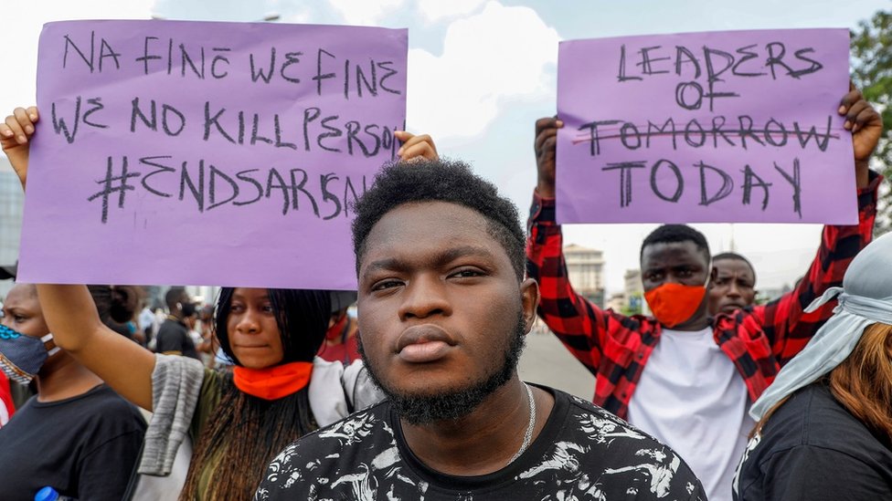 Демонстранты держат плакаты во время акции протеста против предполагаемой жестокости полиции в Лагосе, Нигерия
