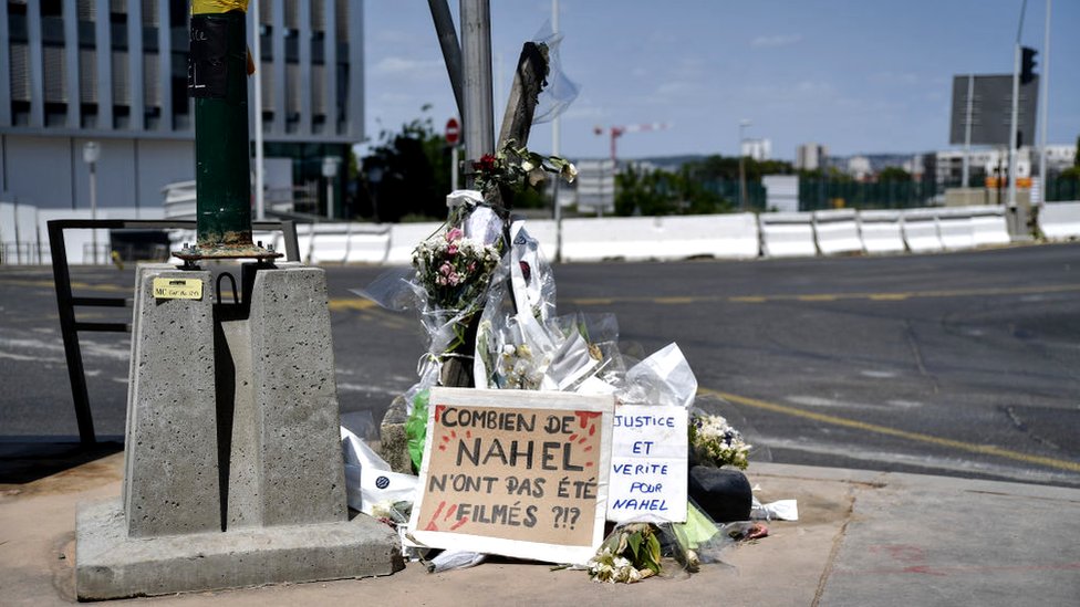 Flowers and banners placed near the location where 17-year-old Nahel was killed by police in Nanterre, France, 3 July 2023